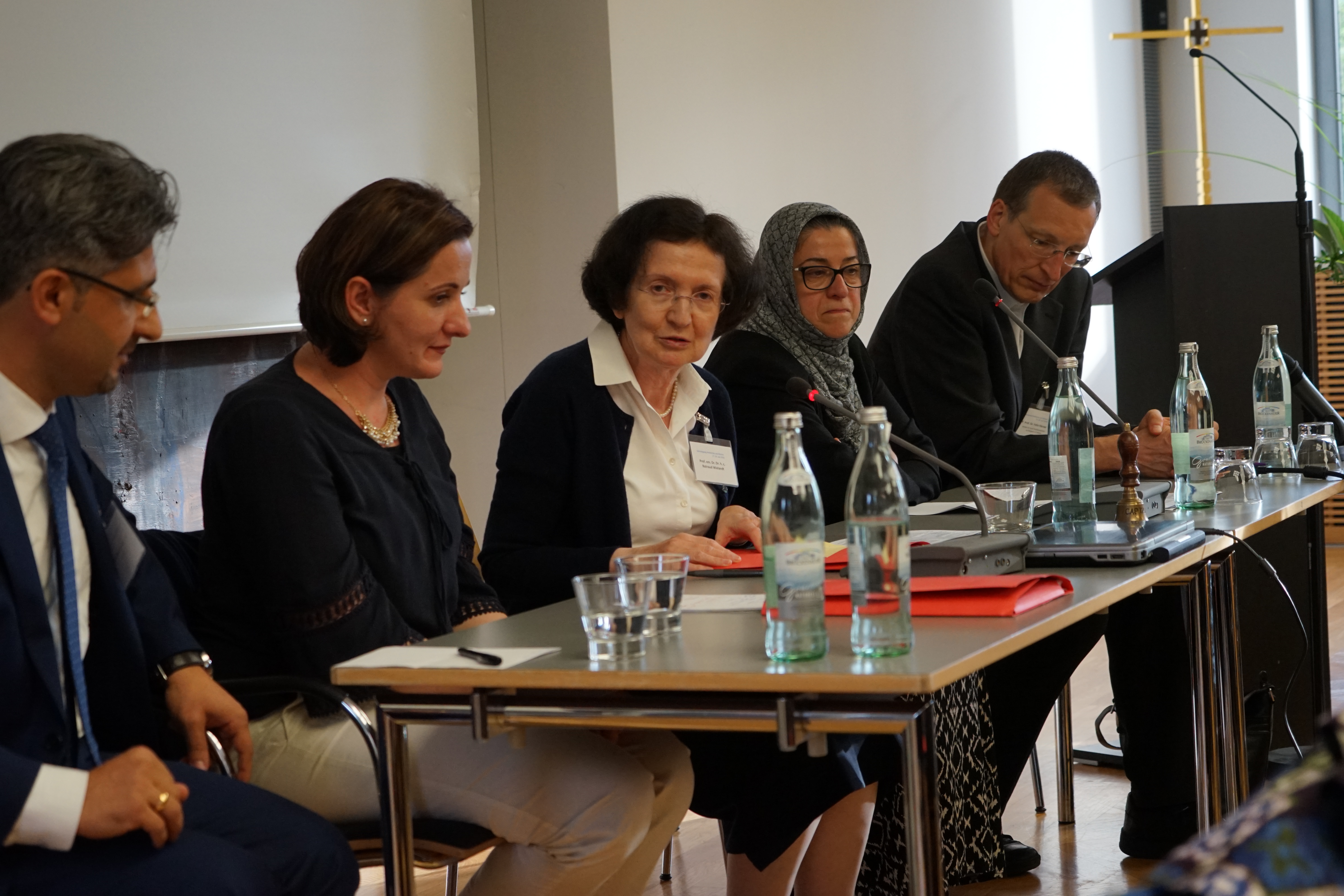 Fünf Personen auf dem Podium der Jahrestagung, darunter eine Frau mit Kopftuch